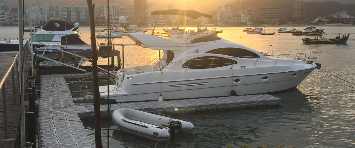 Lancha atracada em marina de Balneário Camboriú ao pôr do sol